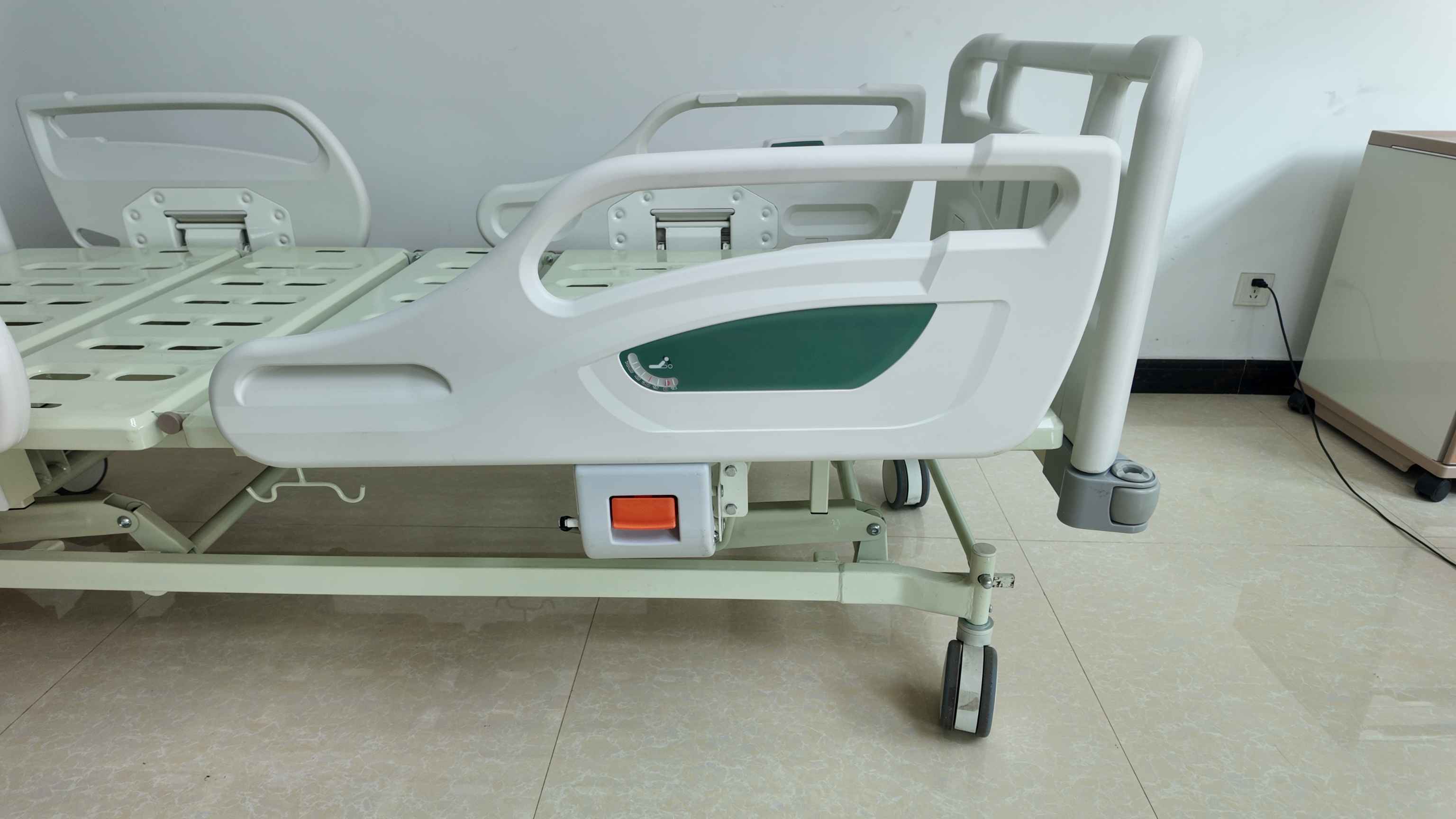 Front view of the green bedside three-function manual hospital bed
